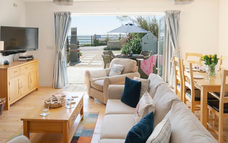 Outside View of a Holiday Home taken from Living area including Outdoor Dinning area and Sea Views