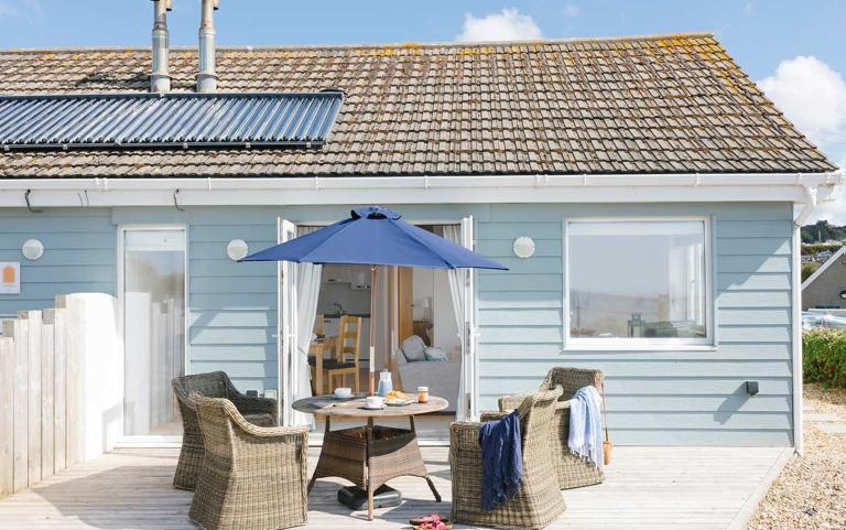 Outside View of a Holiday Home with a Decking area and Dining Table & Chairs