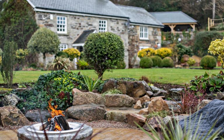 Outdoor View of Cottage in Beautiful Gardens Featuring outdoor Fireplace