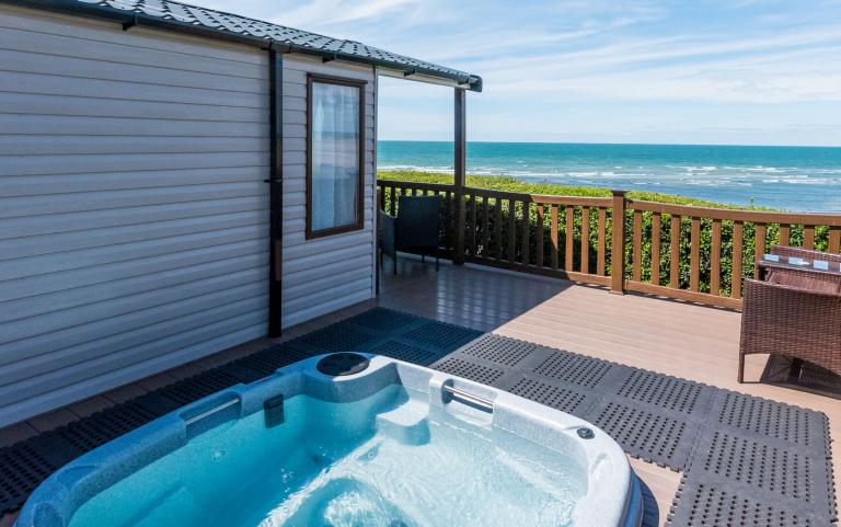 Outside Decking Area of a Caravan Holiday Home with a Hot Tub which benefits from Views over the Sea